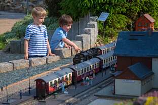 Kinder bestaunen die Miniatur-Eisenbahnen